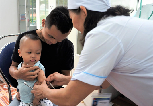 Baby being held while getting vaccinated