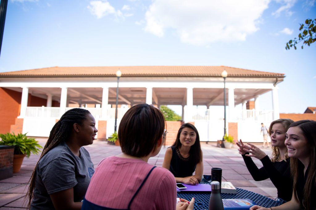 Photo of students discussing coursework at a table