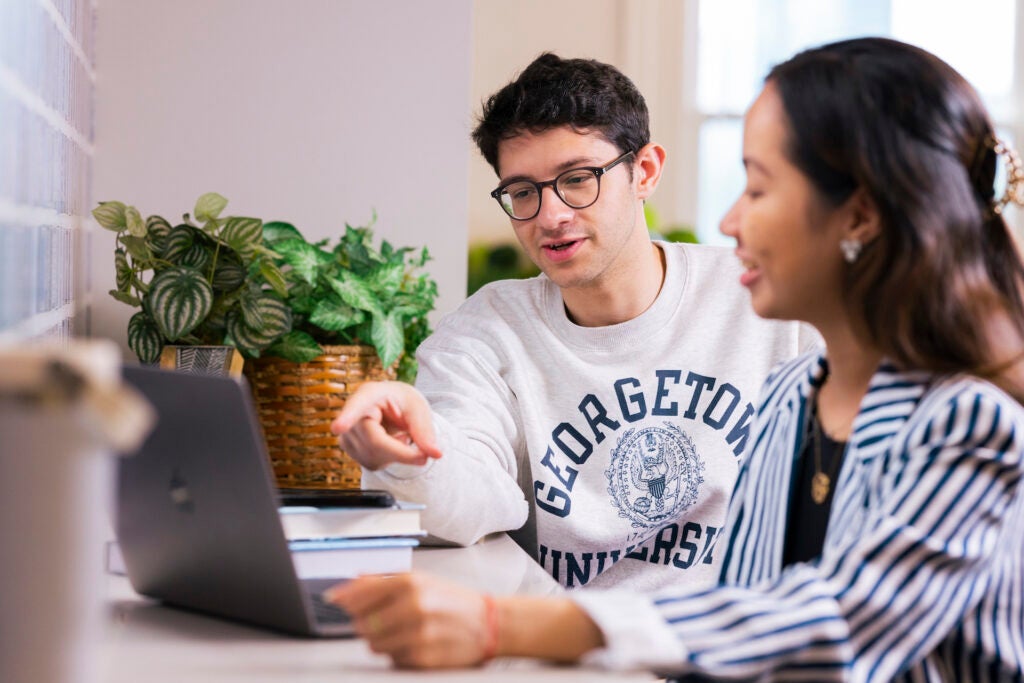 two students at a computer talking